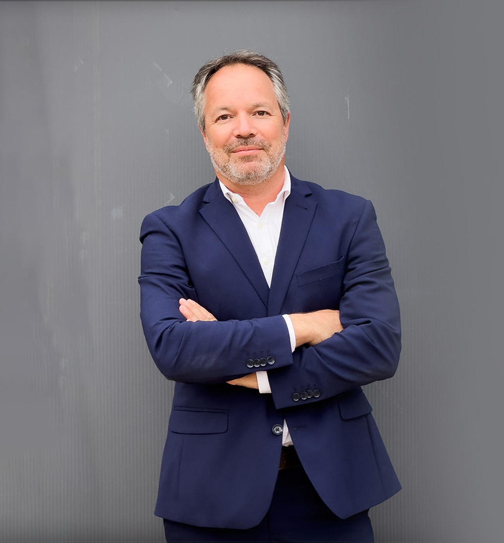 expert immobilier lmnp souriant, bras croisés, veste de costume bleue nuit, chemise blanche immaculée
